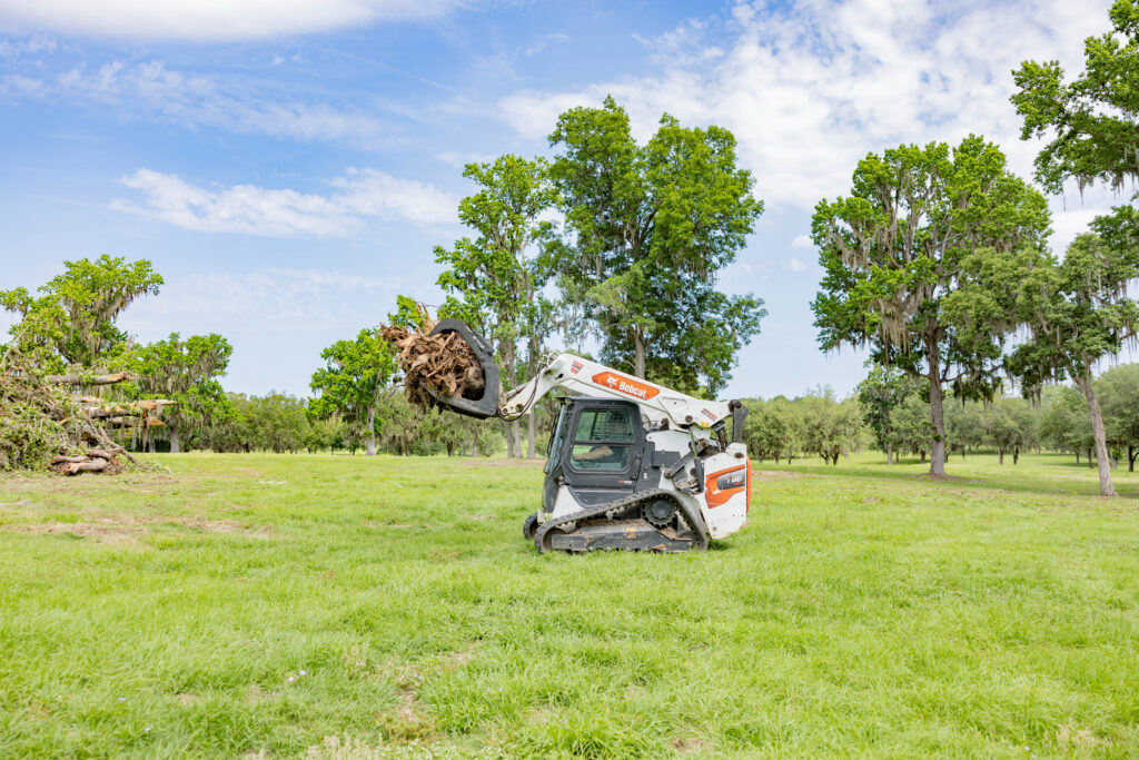 Skid steer clearing land for pole barn site preparation