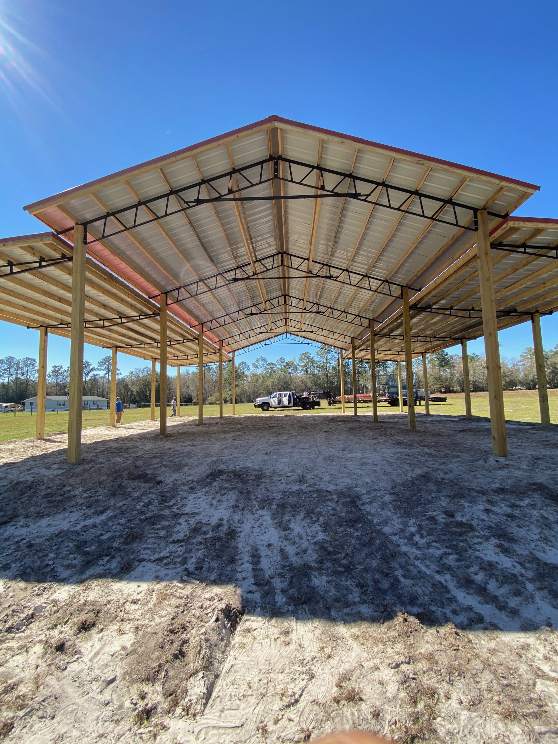 Open pole barn kit with a tractor parked underneath, built by Southern Pro Pole Barns in Marion County